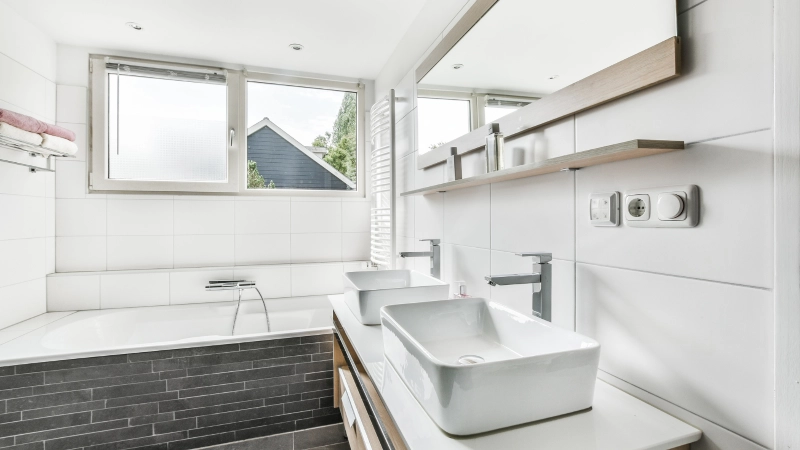Modern white bathroom renovation by GC LLC in Edmond OK, featuring large windows, built-in tub and clean tile design